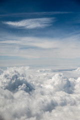 Aerial view of fluffy white clouds under a blue sky with wispy clouds