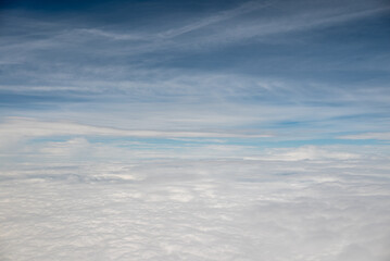 Aerial view of fluffy white clouds under a blue sky with wispy clouds