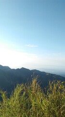a view of the mountains illuminated by the sun's reflection and a clear blue sky without clouds