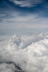 Aerial view of fluffy white clouds under a blue sky with wispy clouds