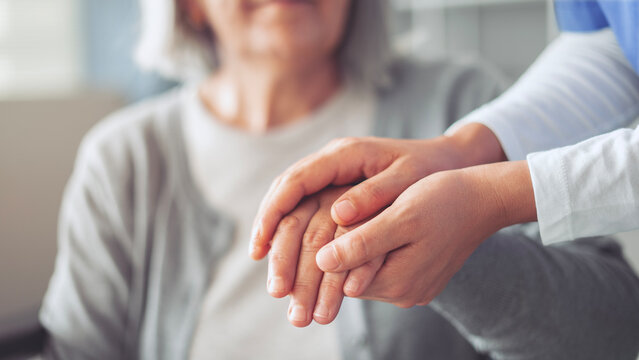 Hands holding old woman's hands