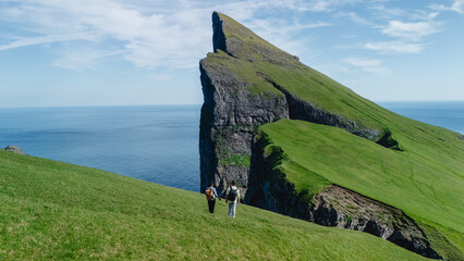 Exploring the stunning cliffs of Vagar in the Faroe Islands under a clear blue sky