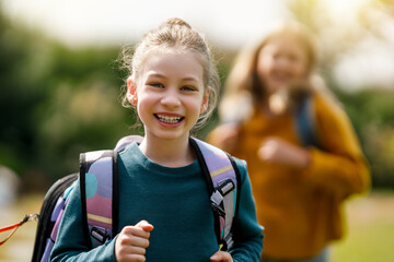 Girls with backpacks are going to school