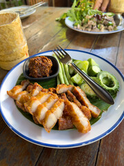 Grilled Thai pork neck served with chili paste, bitter melon, beans and cucumber