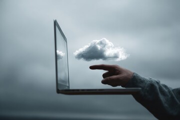 Hand points to a cloud reflected on a laptop screen against a cloudy sky