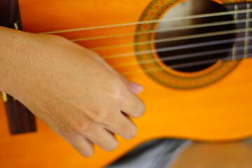 Fototapeta premium close-up shots of hands playing the guitar, showcasing different finger positions and techniques, perfect for music enthusiasts and instructional content