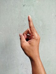 Raising hand of man on grey background
