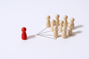 Obraz premium Conceptual Image of Leadership and Teamwork, Featuring Wooden Figures Connected by Lines on a White Background