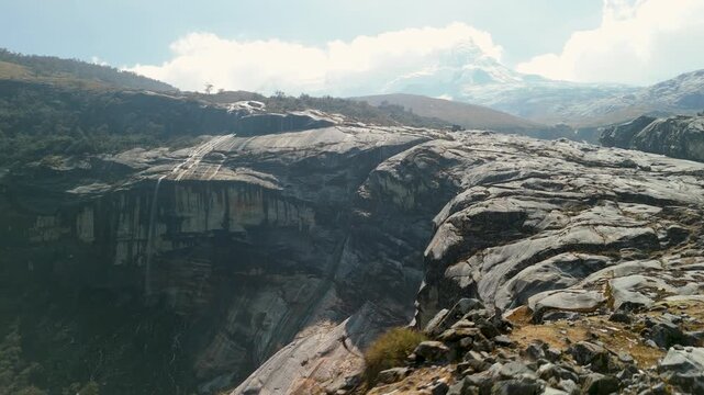 A stunning high-altitude rocky landscape with Hualc&aacute;n Mountain rising above Laguna 513 in Peru's Cordillera Blanca - aerial flyover