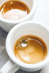 Close-up of Two White Espresso Cups With Rich Crema Served on Countertop, Top View