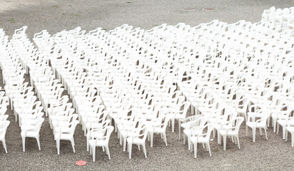 Rows of white plastic chairs