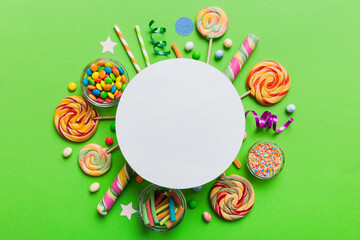Flat lay holiday composition. Paper blank, lollipop, birthday decorations on Colored background....