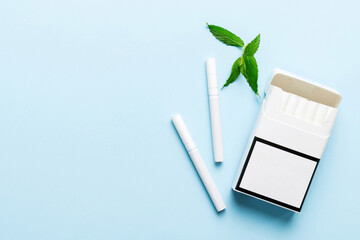 Pack of menthol cigarettes and fresh mint on colored table, Menthol cigarettes top view flat lay