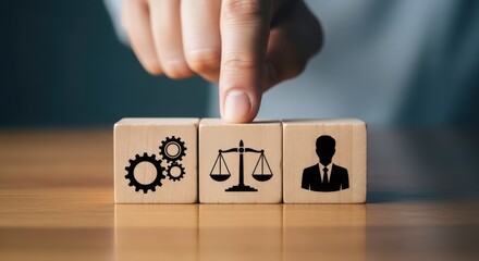 A hand pointing at wooden blocks with gears, scales of justice, and a business man silhouette icon