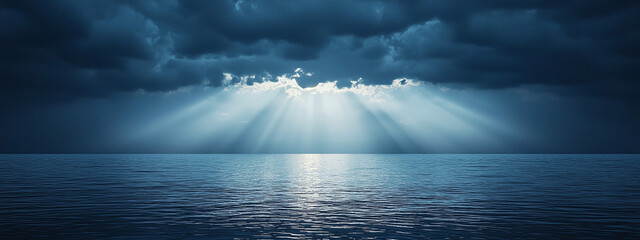 Panoramic view of beautiful calm ocean with stormy sky through which sun rays shine through