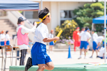 中学校の体育祭でリレーを走る男子生徒