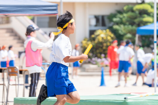 中学校の体育祭でリレーを走る男子生徒