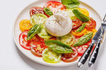 Fresh burrata served on slices of colorful tomatoes