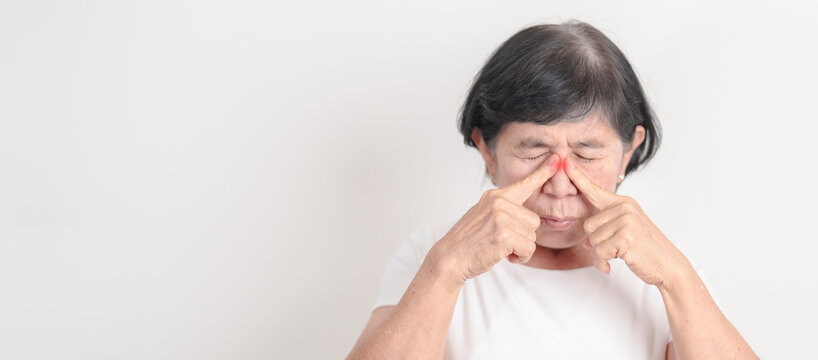 Elderly Woman having Nose pain for concepts of Nose disease, Common Cold, Influenza, Flu, Covid 19, Respiratory Infection, Sinusitis, Allergic Rhinitis, Asthma, Allergy, Dry nose Anosmia and Health