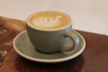 Cup of Cappuccino with Latte Art on a Wooden Coffee Table