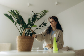 Young Woman Caring for Plants Indoors with Cleaning Products
