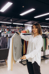 Smiling Woman Shopping for Clothes in a Fashion Boutique Setting