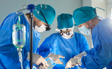 Surgeon team performs operation on patient in hospital operating room, executing emergency...