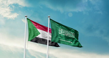 Sudan and Saudi Arabia friendship flags are waving in the sky. Two country flag for agreement or...