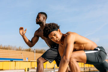 Hispanic men engage in outdoor workout session under clear blue sky