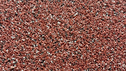 Rough Red Granular Surface with White and Black Particles — Ideal Background for Construction, Landscaping, and Graphic Projects
