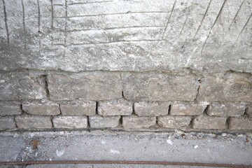 Damaged exterior wall of a house with visible missing plaster. Rough texture, suitable for background use.