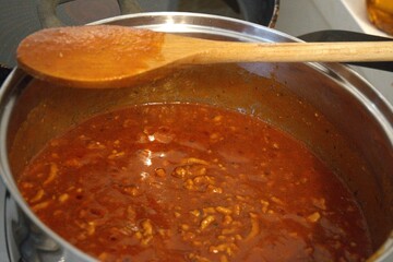 Freshly cooked homemade Bolognese sauce in a stainless steel pot. Rich and hearty meat sauce.
