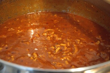 Freshly cooked homemade Bolognese sauce in a stainless steel pot. Rich and hearty meat sauce.