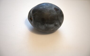 Ripe purple plum isolated on a white background. Close-up with generous copy space.