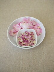 Fresh and dried petals from the wild dog rose on a plate, Rosa canina