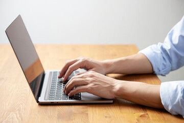 Naklejka premium Typing on laptop keyboard for work or study from home side view stock photo image