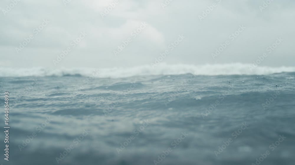 Poster closeup of rain falling on ocean creating rhythmic motion and textures