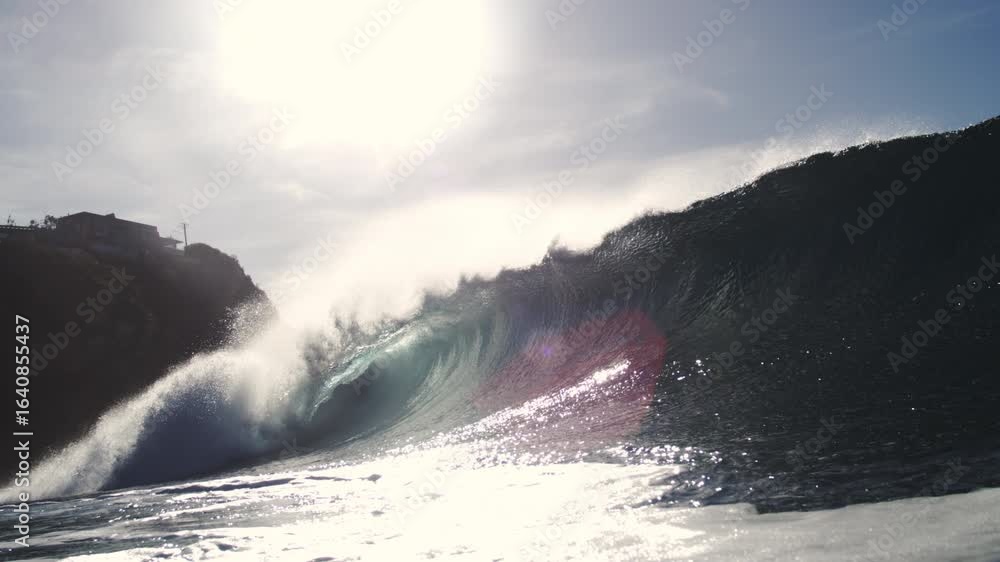 Poster glassy wave crashes in slow motion with shimmering backlight