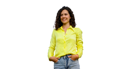 Cheerful young woman with curly hair wearing yellow shirt and blue jeans, standing relaxed with hands tucked in pockets against transparent background