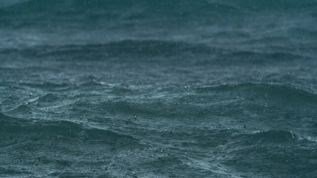 Super slow motion of rainfall hitting ocean in rich textured detail