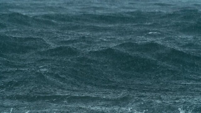Super slow motion rain textures form across ocean with in water detail