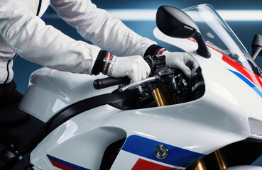A person wearing gloves adjusting a white motorcycle with blue and red accents