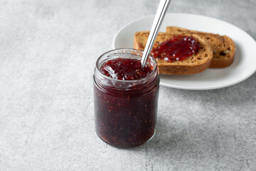 A view of a jar of raspberry preserves.
