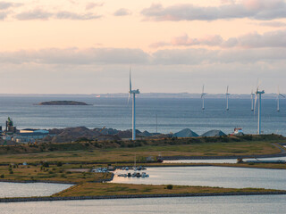 Aerial view of Copenhagen's coastal area with wind turbines near the water, industrial structures,...