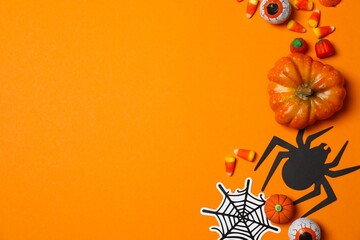 Top view of Halloween festive background design featuring pumpkin, candies and spiders. Happy Halloween holiday concept