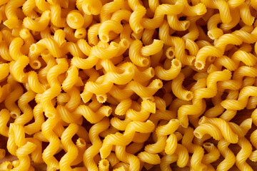 A top down view of a pile of gluten-free cavatappi, as a background.
