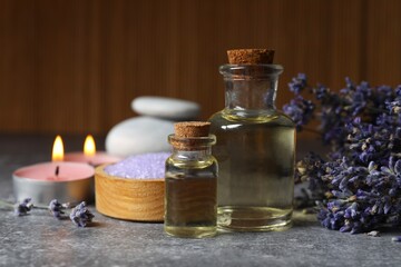 Spa concept. Herbal oil and lavender flowers on gray background. Beauty treatment. Lavender...