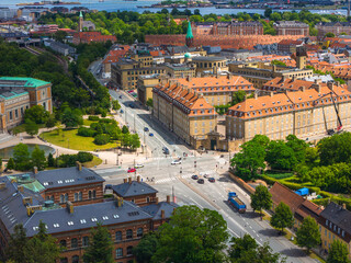 Aerial view of Copenhagen, Denmark, featuring red roofed buildings, tree lined streets, a bustling...