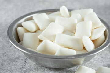 A closeup view of a metal bowl of gum tablets.