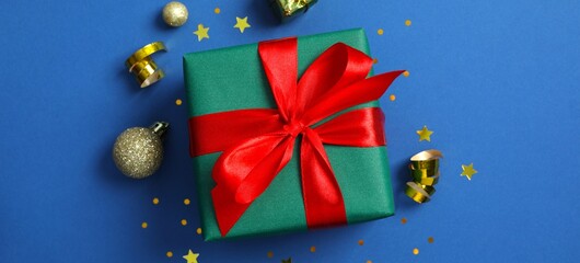 Blue background with holiday theme with decorative gift box, decorations and festive elements...